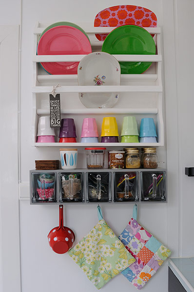 white wall with white shelves and multi-coloured plates and cups