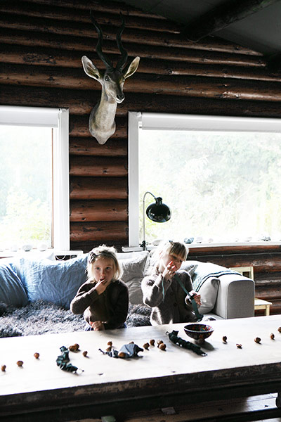 Lounge with children sitting behind table and deer's head
