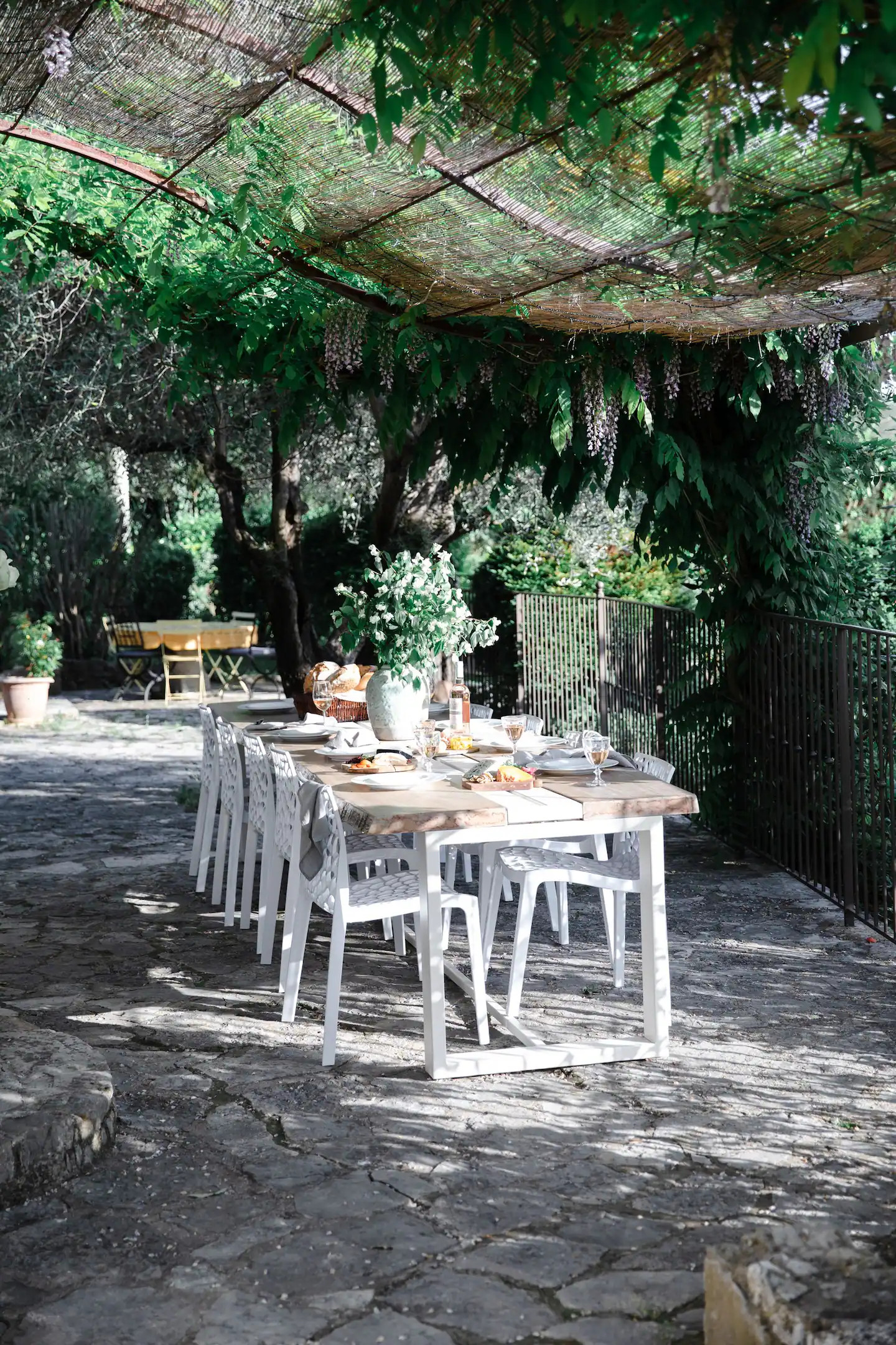 salle à manger extérieure sous pergola métal et canisses