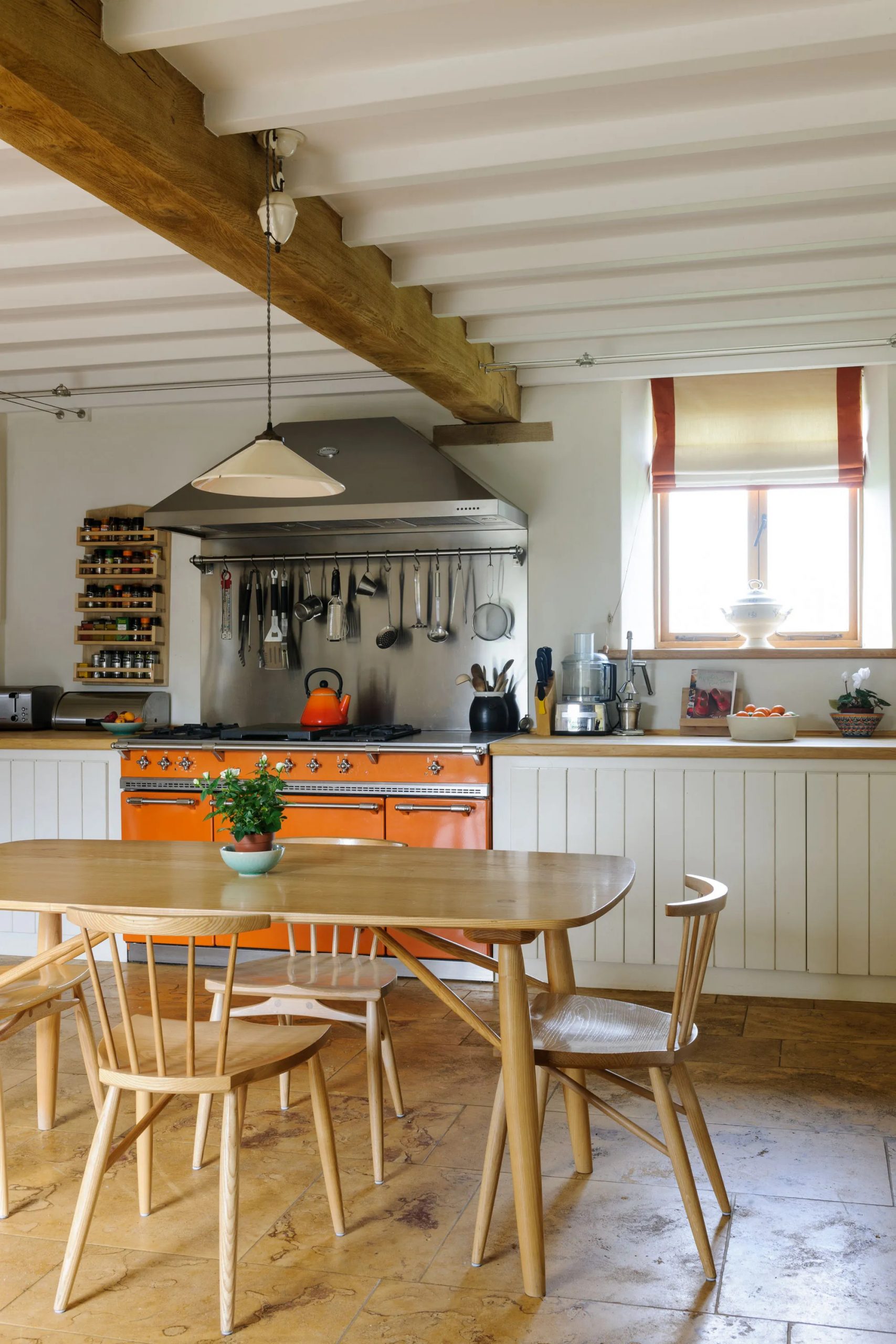 cuisine rustique chic avec piano Aga orange dans grange rénovée