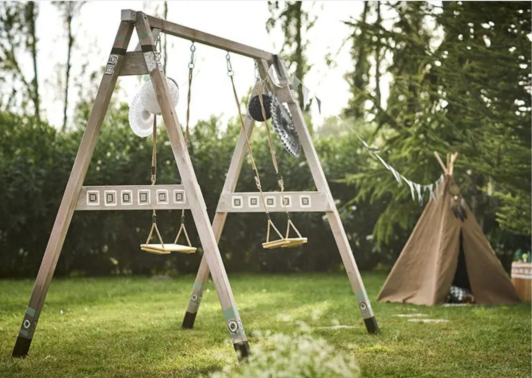 balançoire en bois et tipi dans jardin