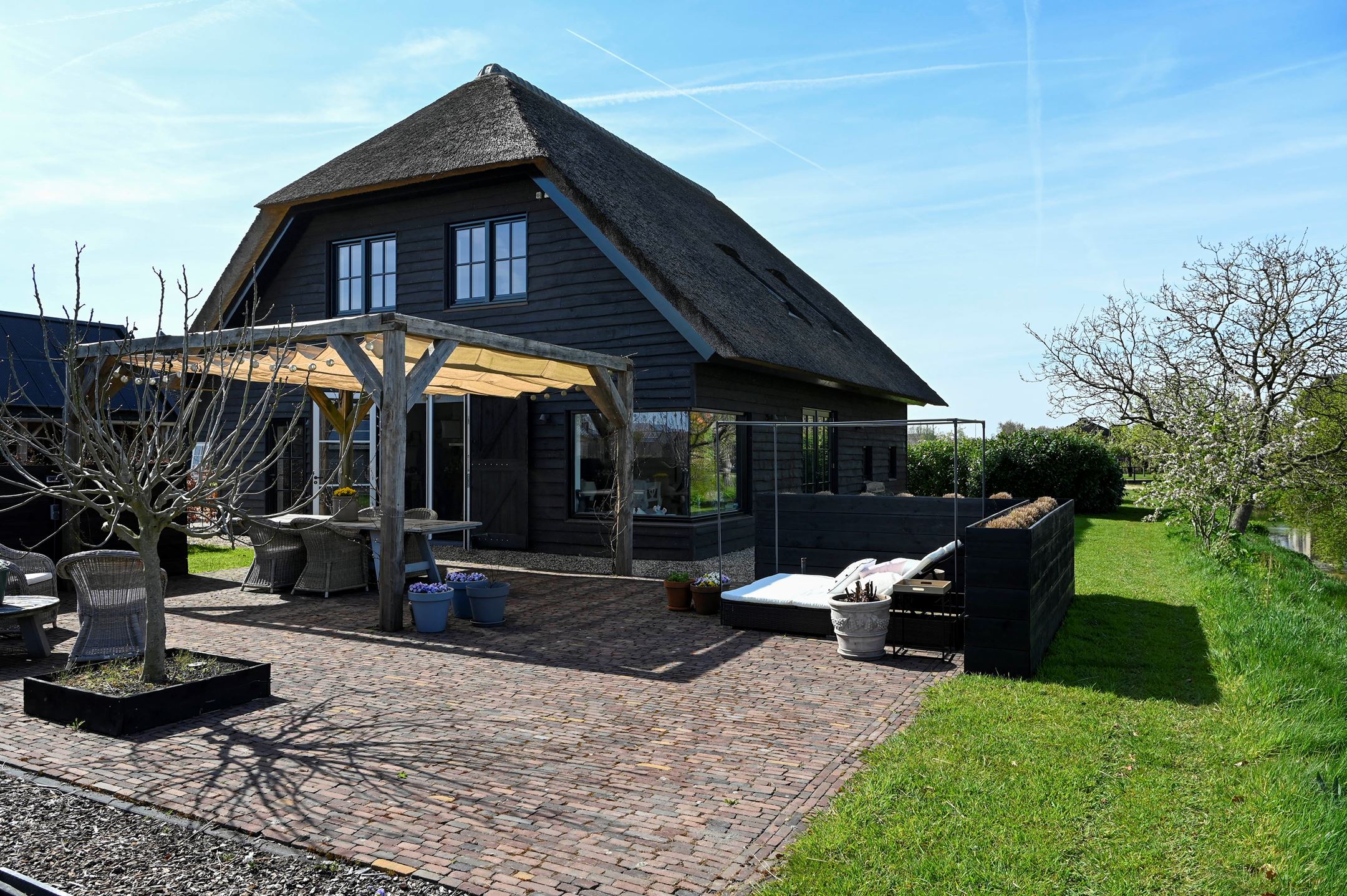 maison bois noir toit de chaume