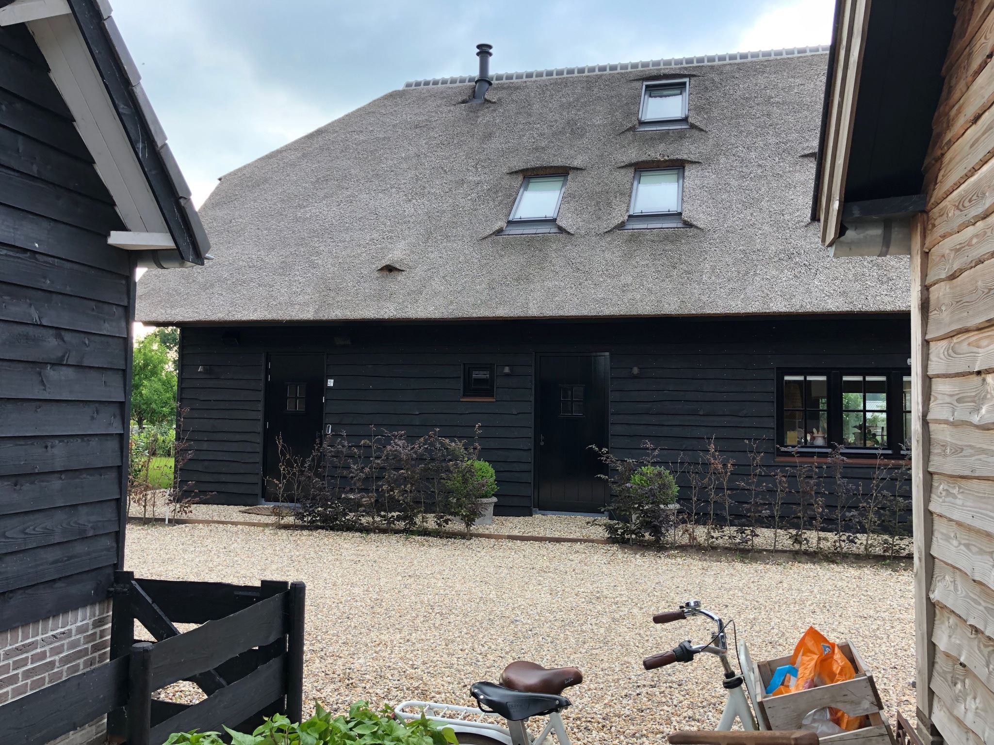 maison bois noir toit de chaume gris