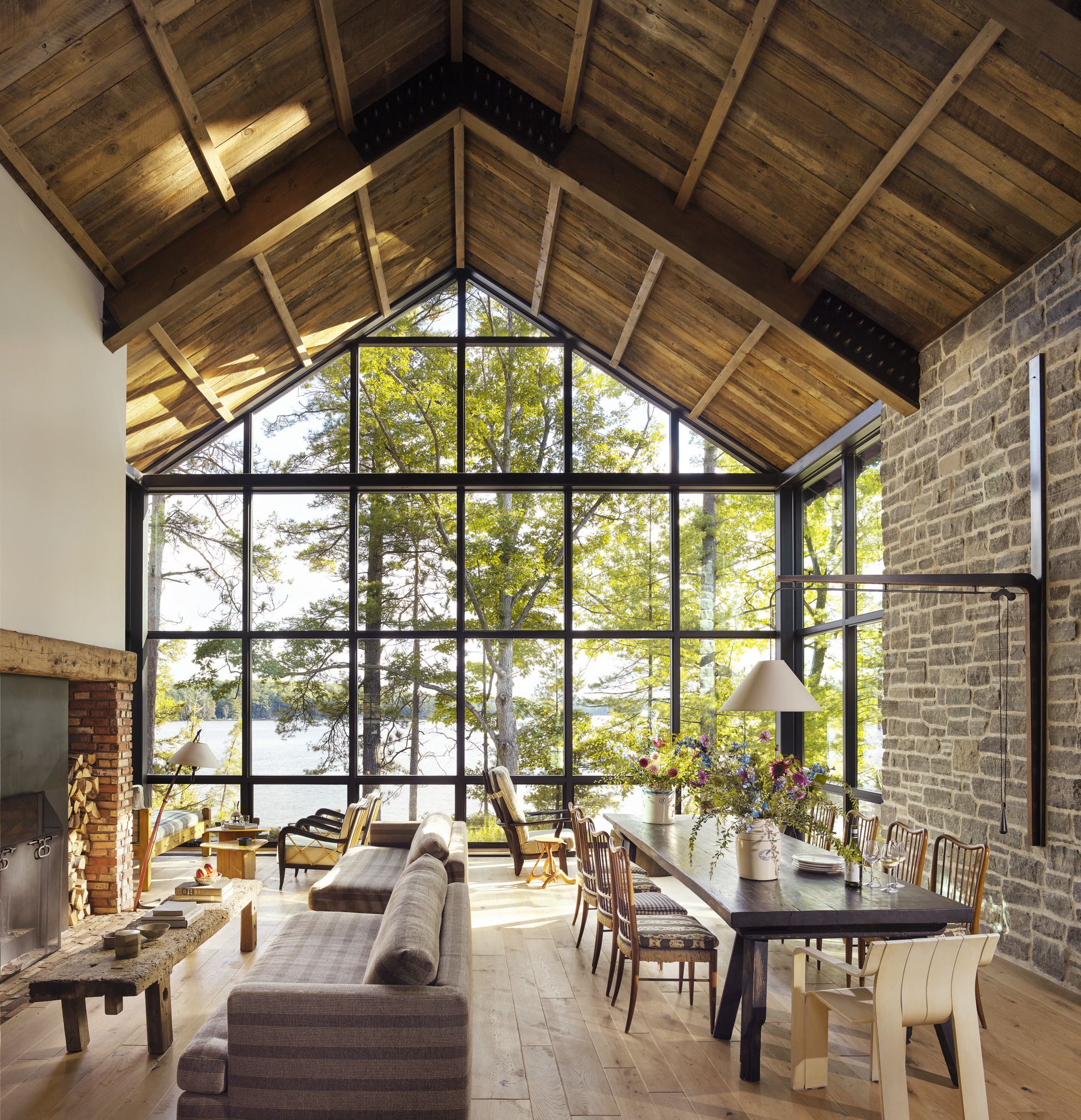 salon avec fenêtre verrière maison en bois sur un lac
