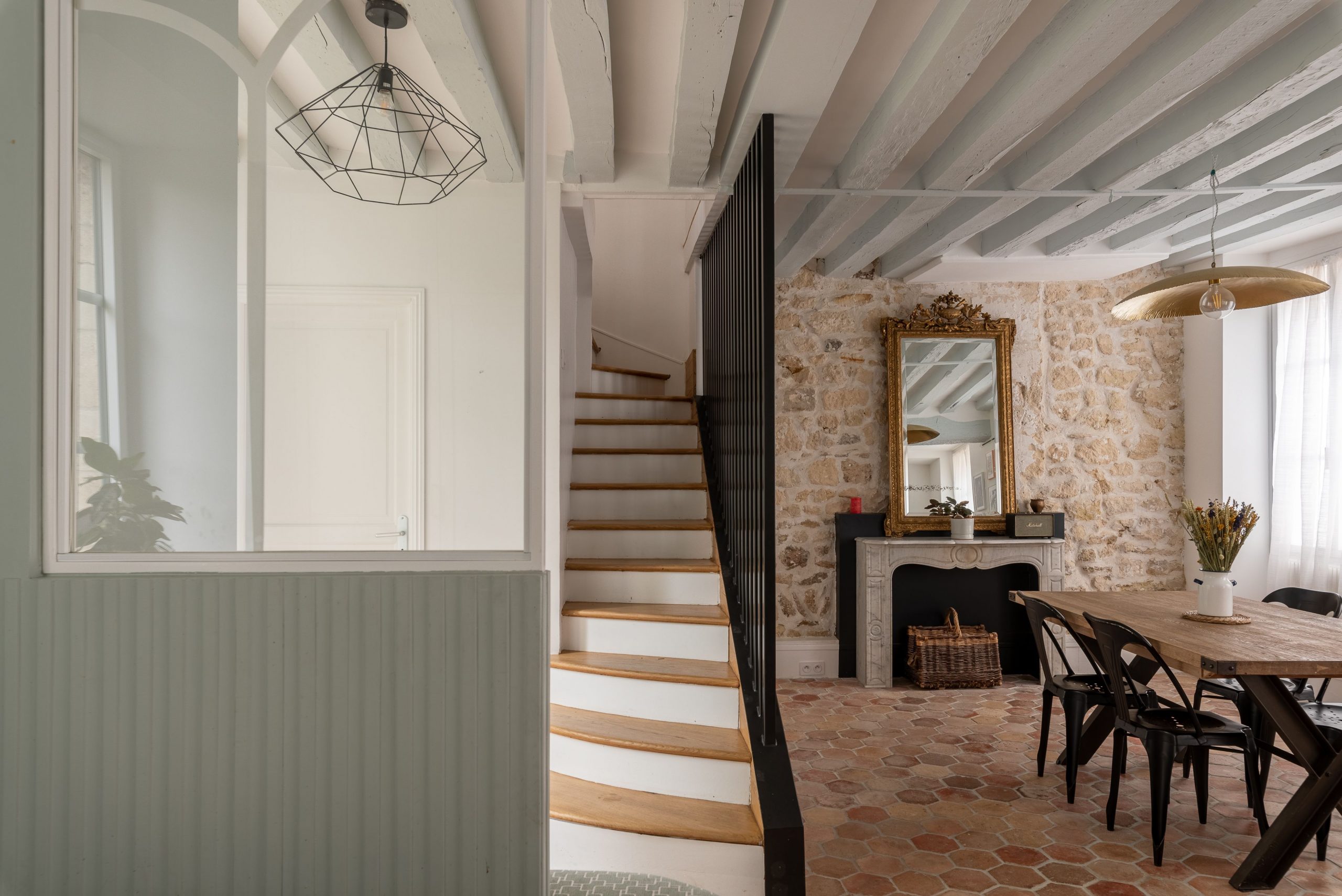 salon avec mur en pierre et cheminée baroque maison rénovée