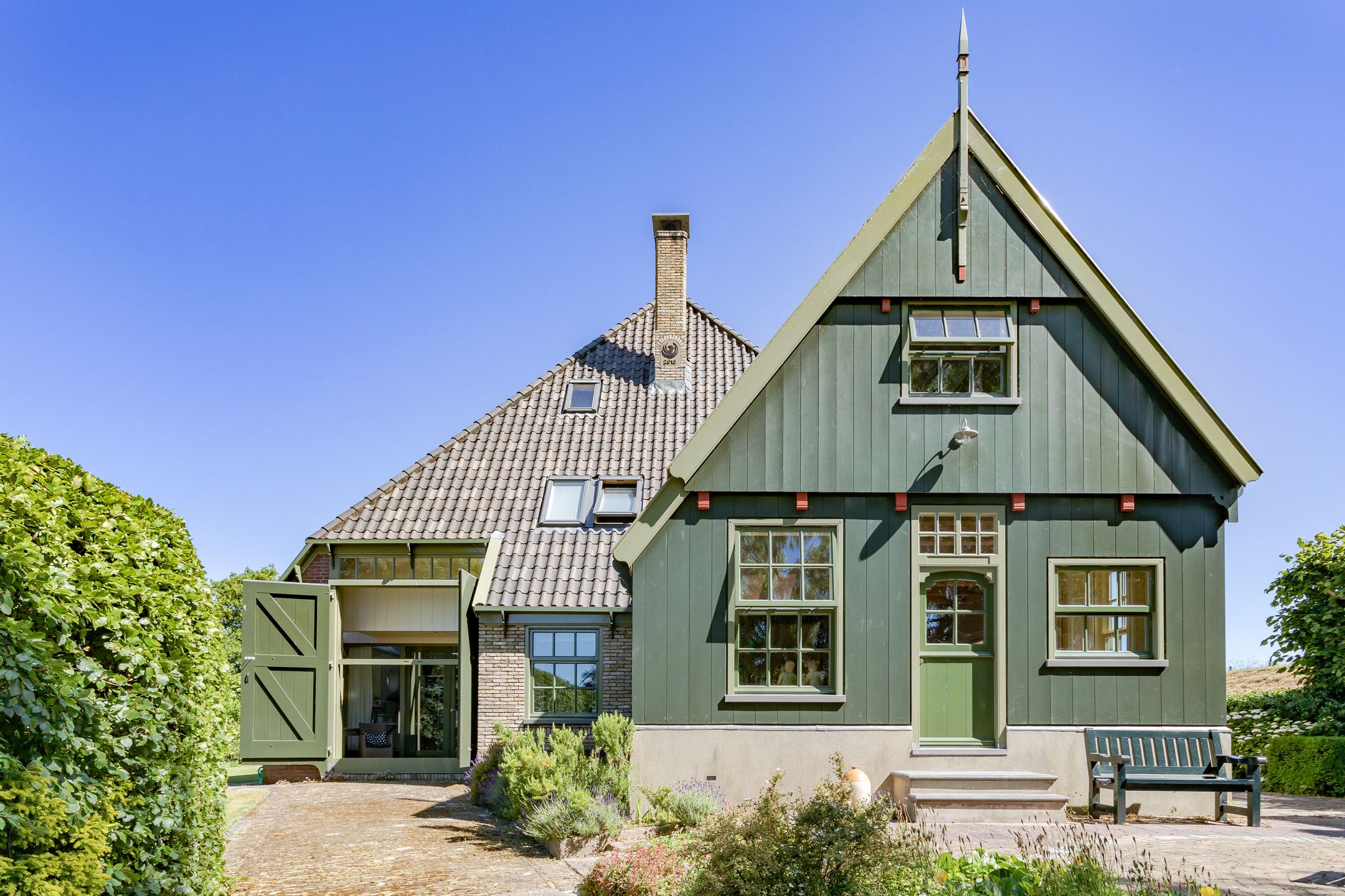 ferme rénovée façade bois vert et briques