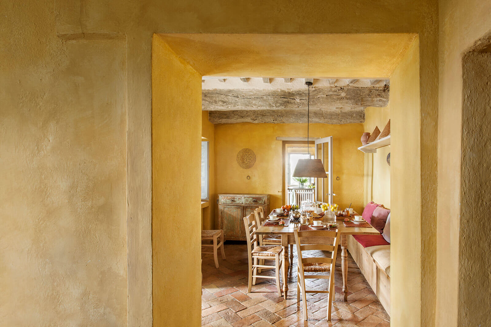 salon avec murs jaunes maison en pierres