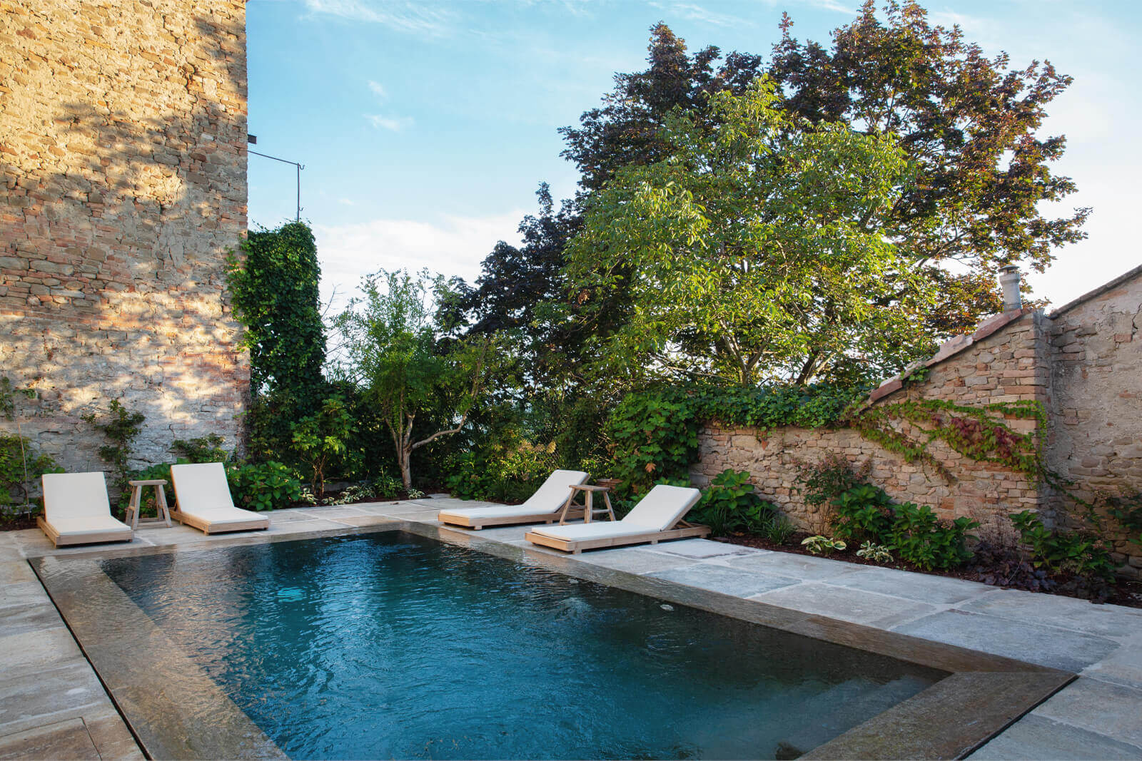 jardin avec piscine et murs de pierres