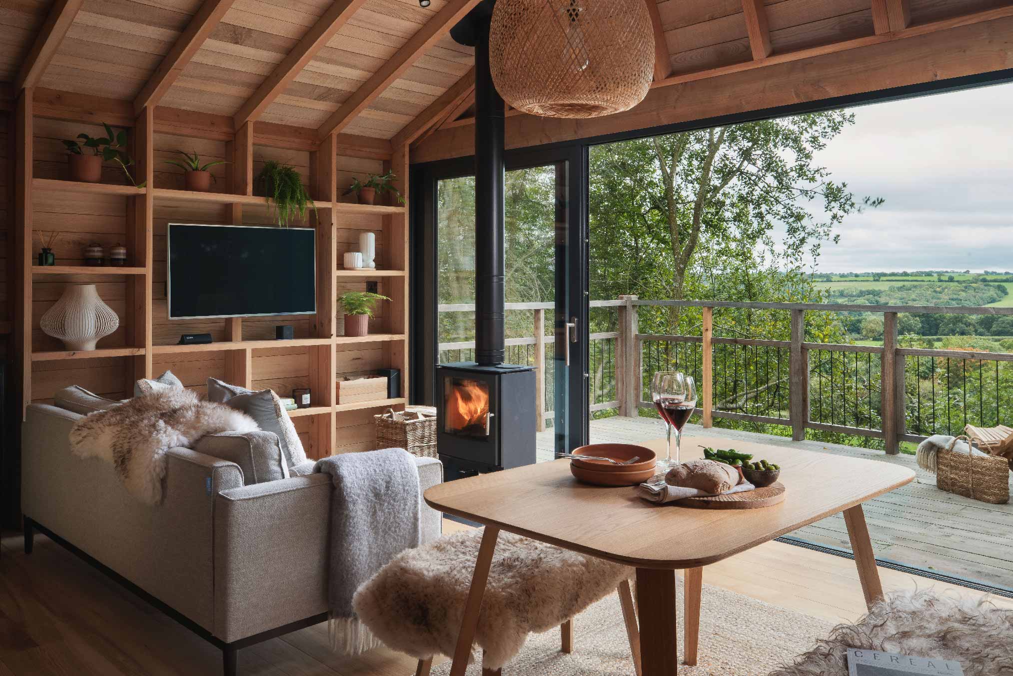 salon maison en bois noir dans les arbres