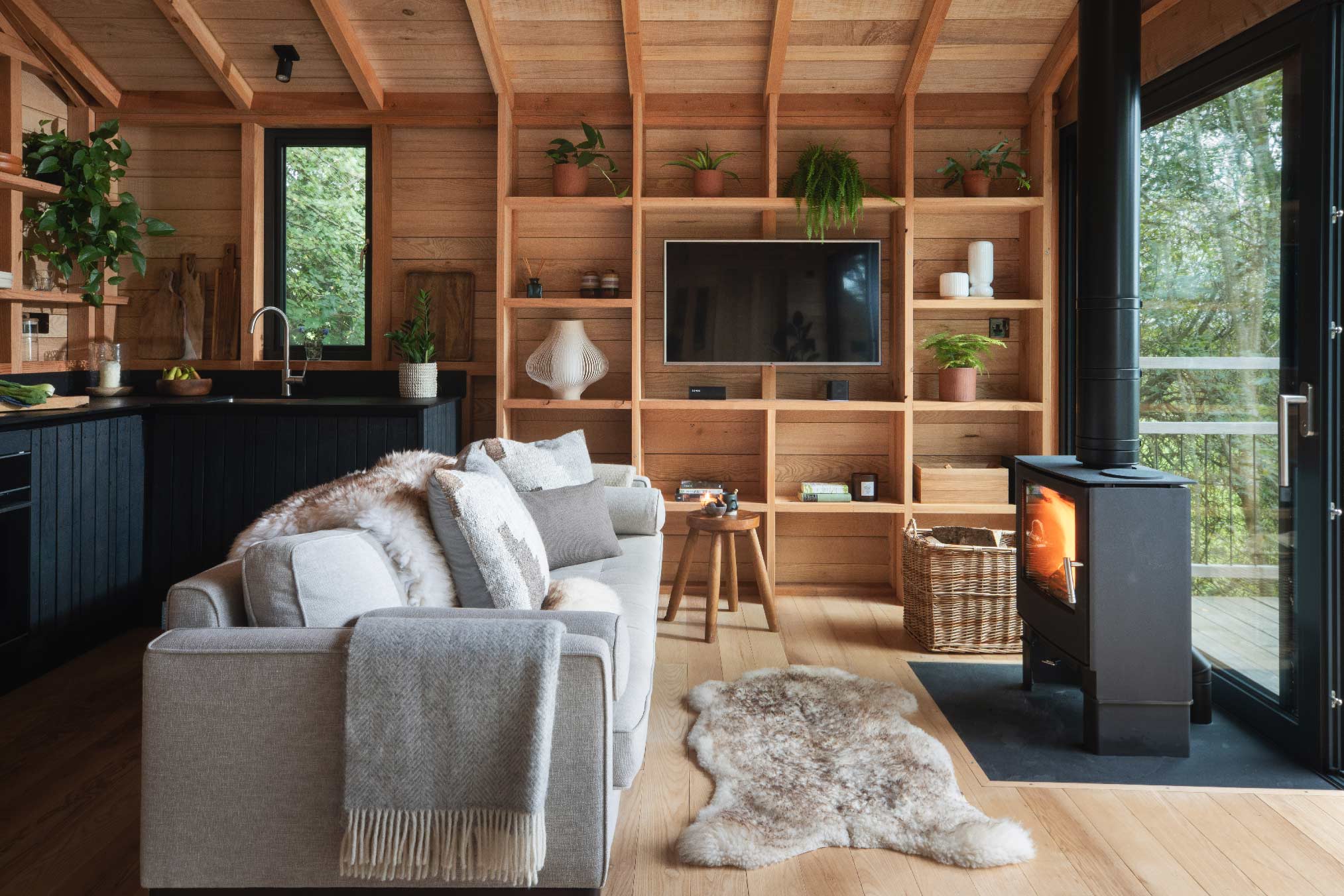 salon maison en bois noir dans les arbres