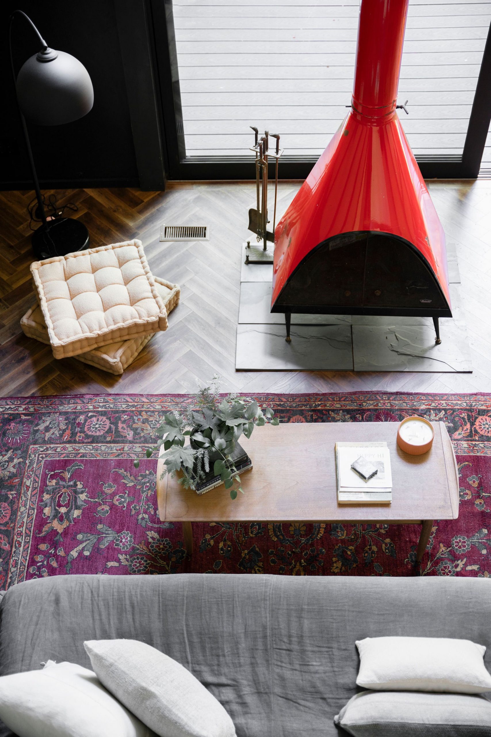 salon décoration noire avec cheminée métal rouge maison A-Frame