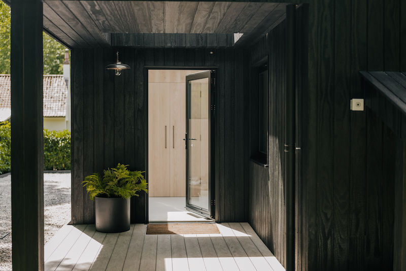 maison en bois noir installée dans un ancien garage