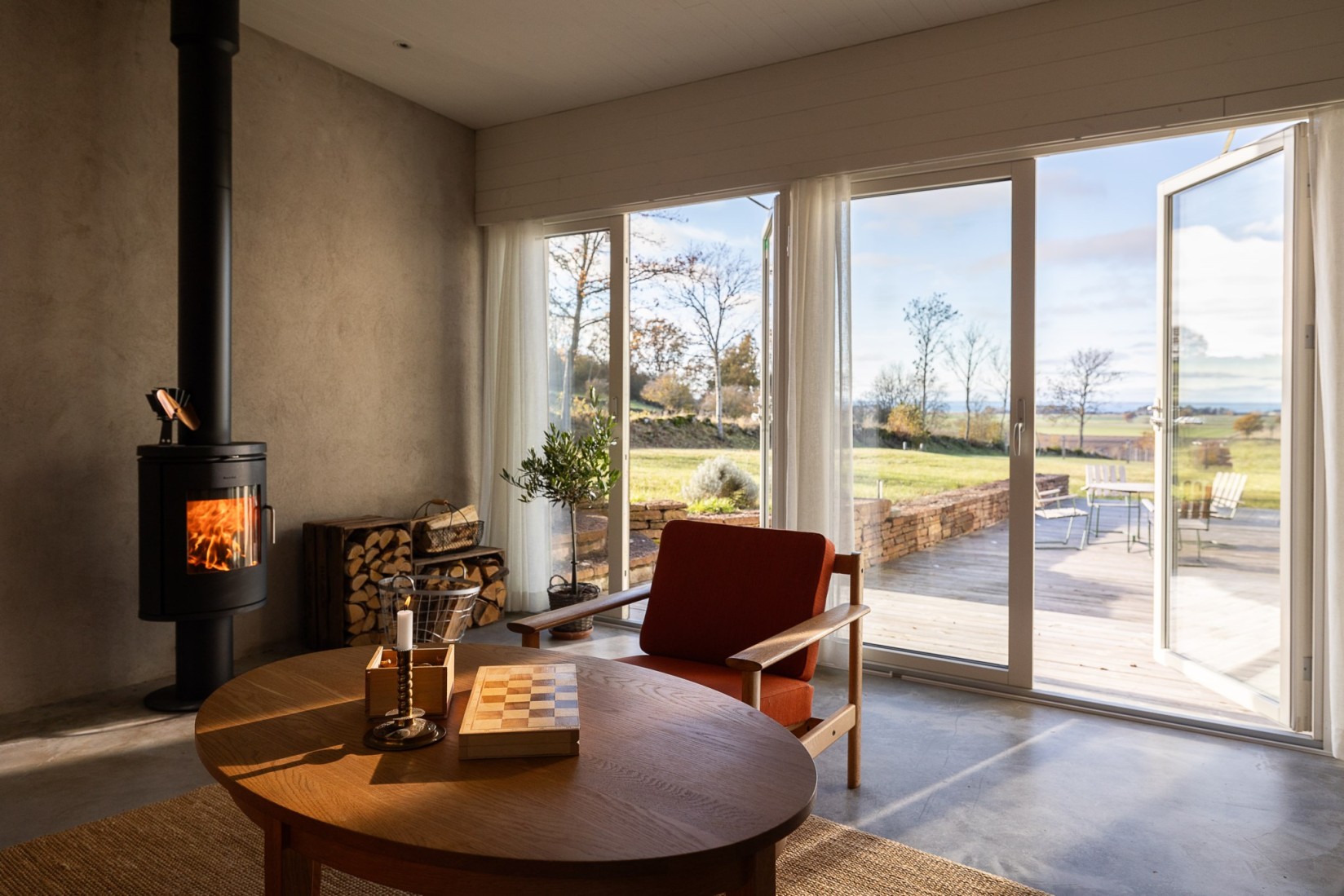 salon avec poêle et baies vitrées grande maison design