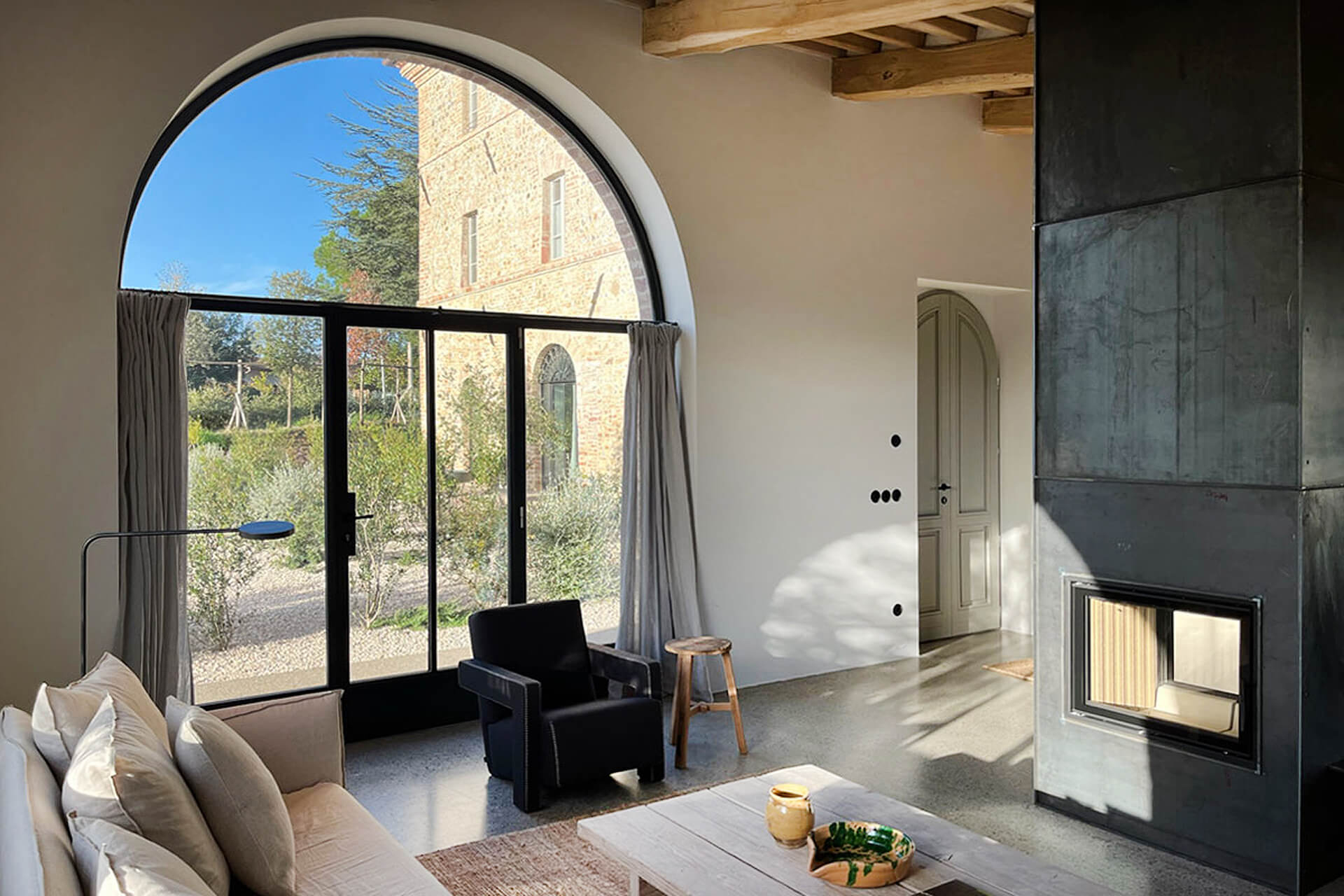 salon avec cheminée et fenêtre en arche décoration contemporaine