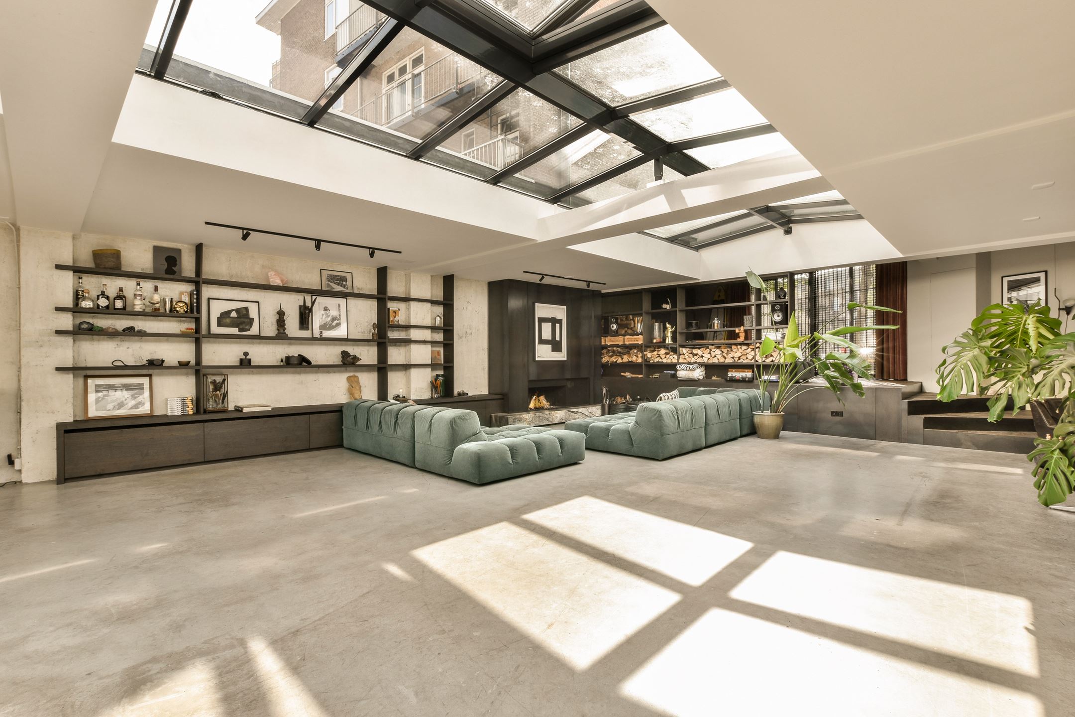 salon canapé vert dans loft avec verrière zénithale