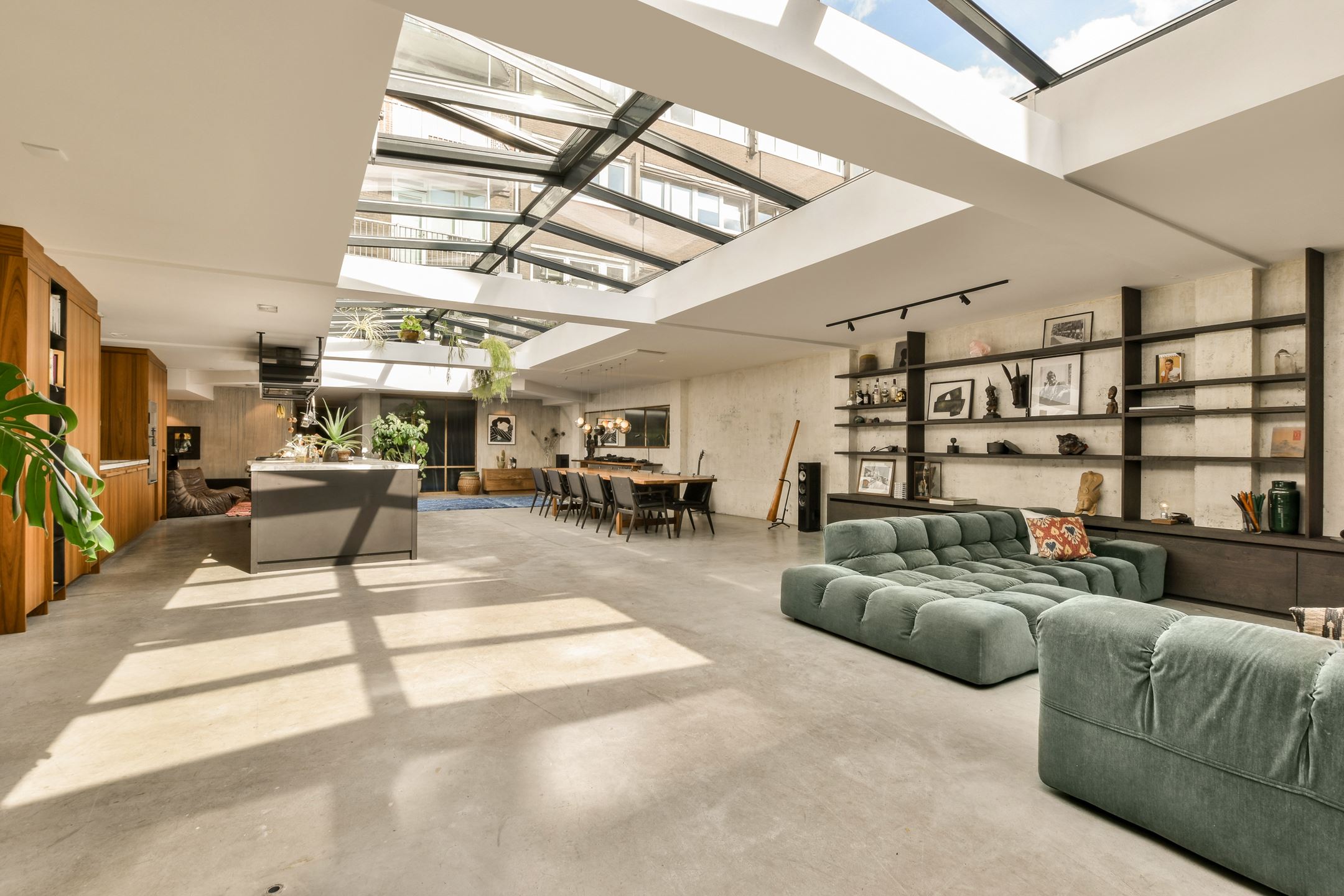 salon canapé vert dans loft avec verrière zénithale