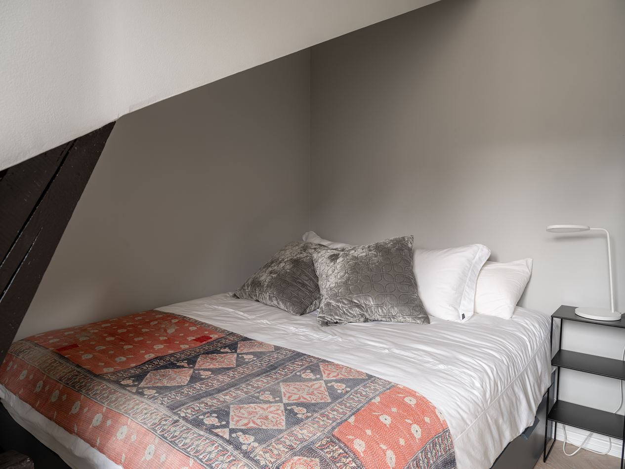 chambre appartement sous combles avec poutres décoration scandinave