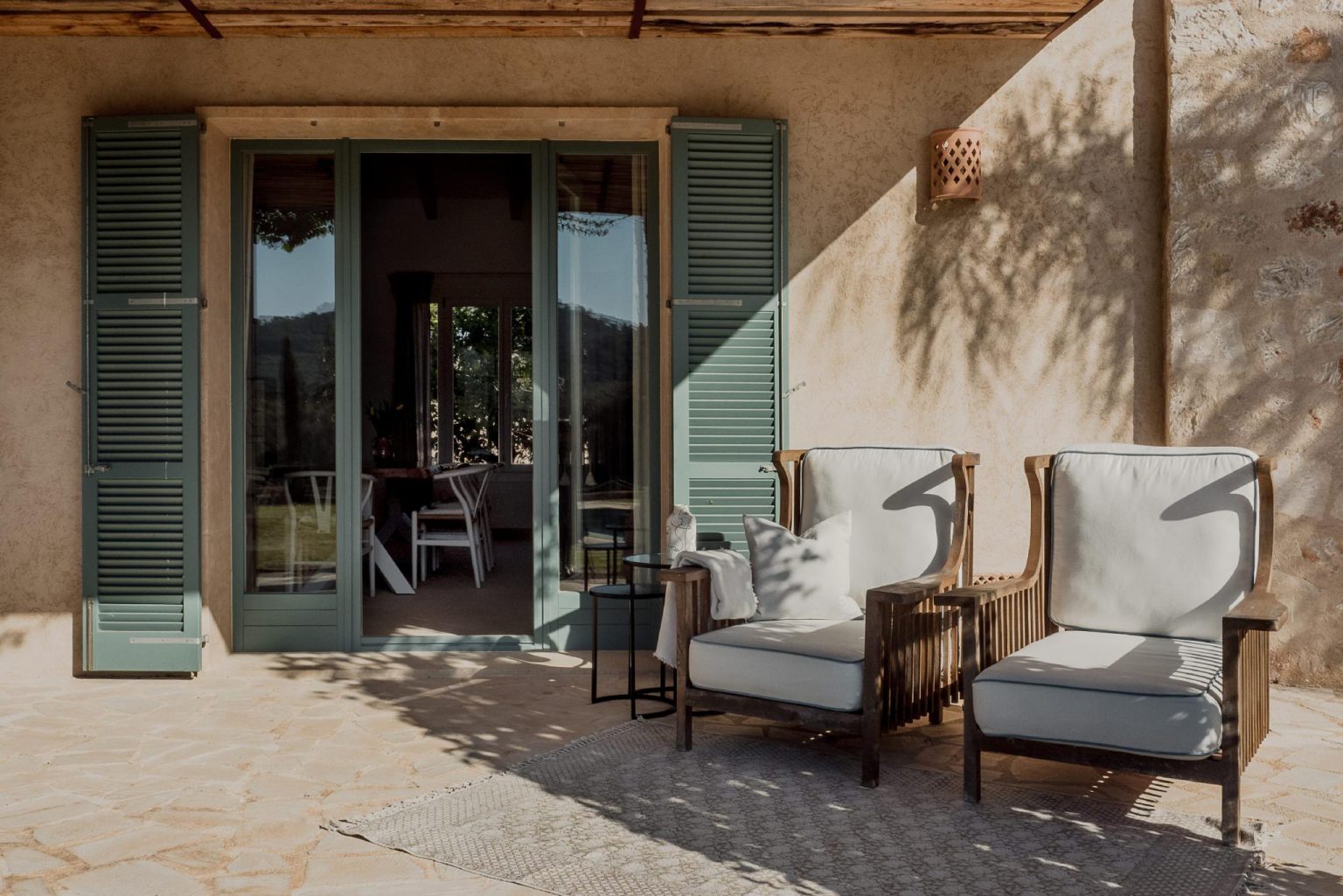 terrasse maison en pierres avec volets verts