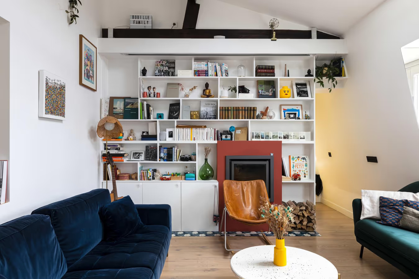 salon mansardé avec poutres et cheminée appartement Paris 