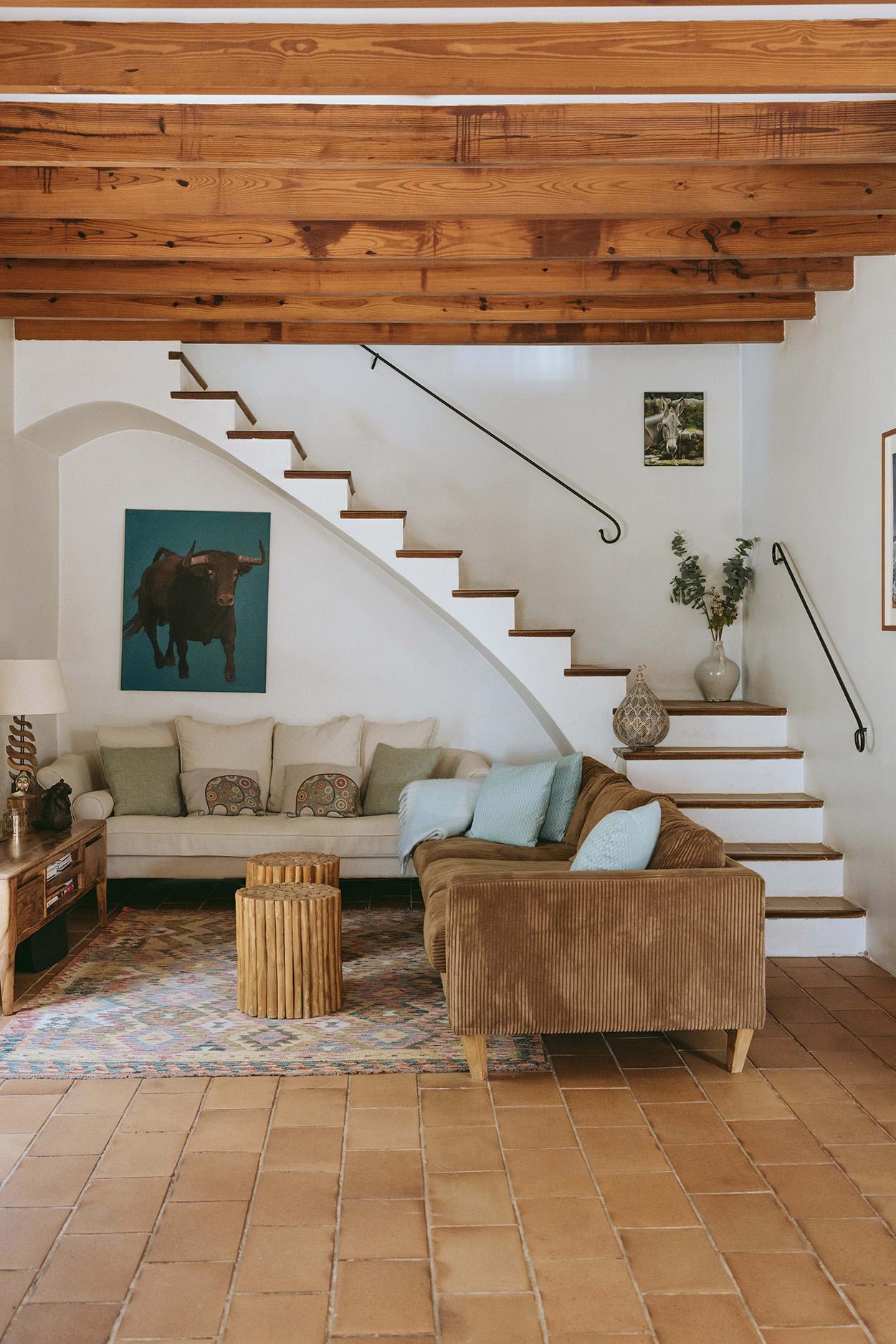 salon avec poutres et escalier maison en pierres