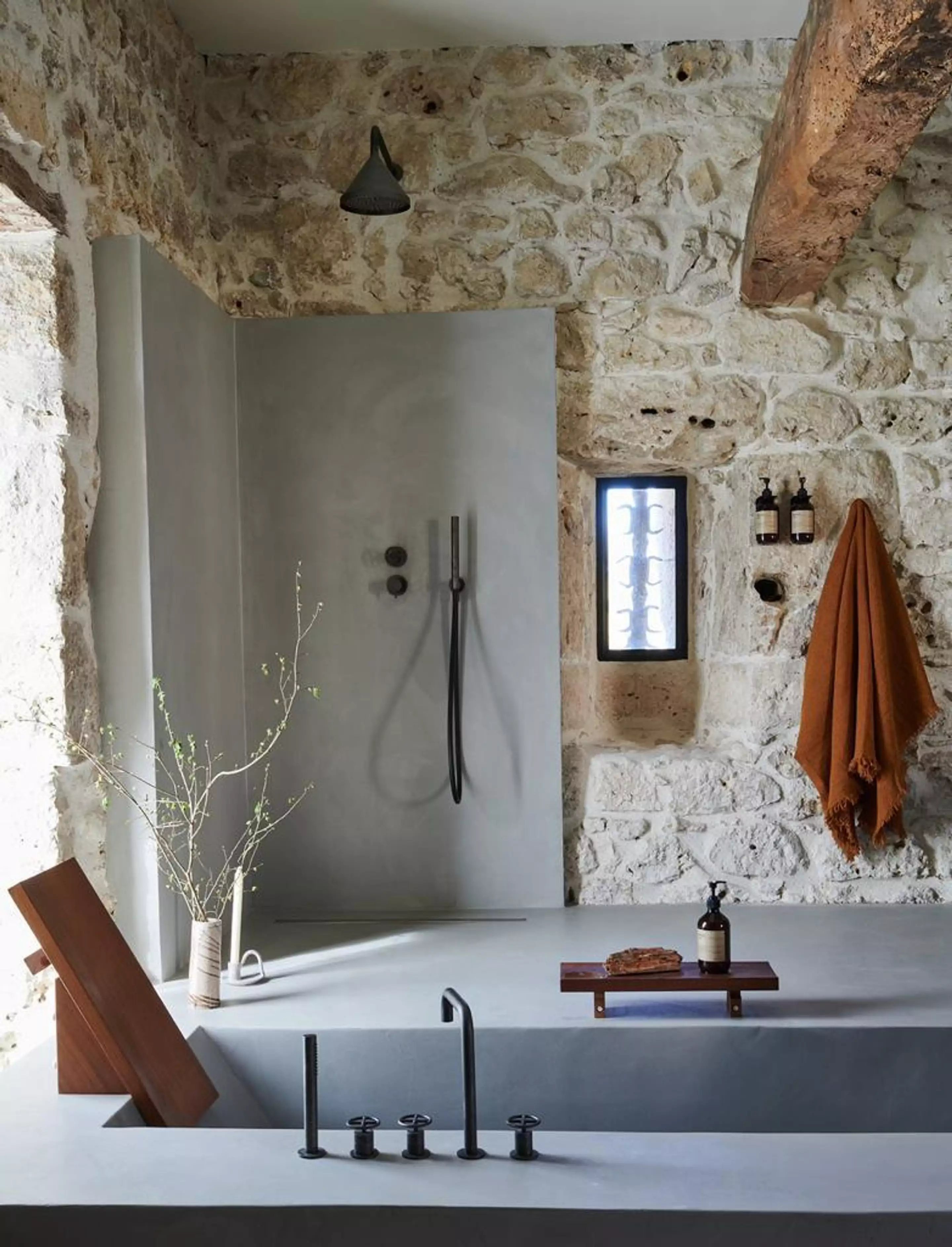 salle de bain contemporaine avec mur pierres et poutres