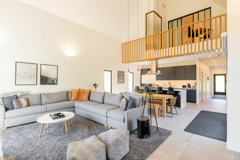 salon double hauteur avec cuisine ouverte maison en bois Villa Prairie