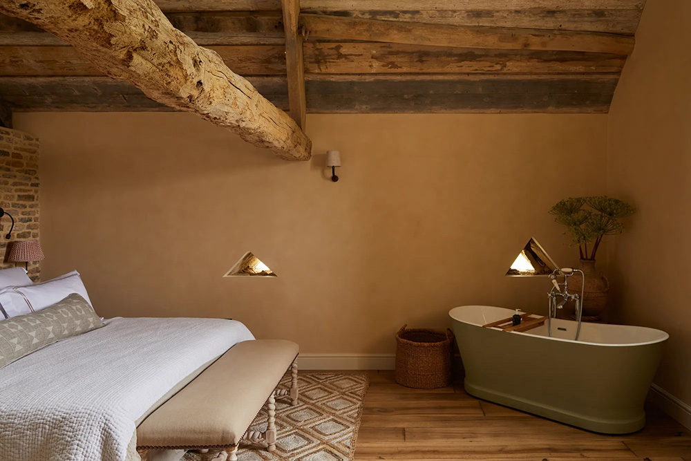 chambre avec poutres et baignoire ancienne ferme rénovée Latimer Farm