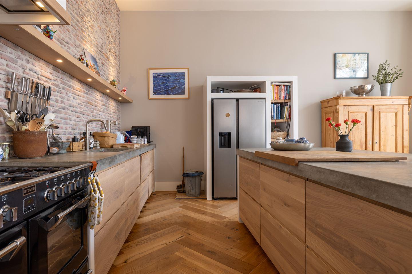 cuisine avec îlot béton et mur de briques appartement en duplex