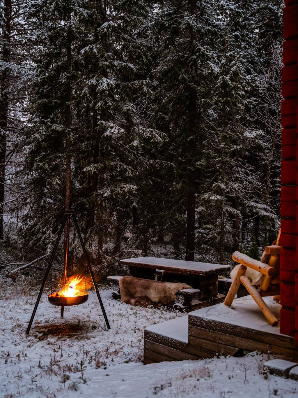 terrasse avec brasero maison en bois rouge dans la neige vue nuit Suède terrasse avec brasero maison en bois rouge dans la neige vue nuit Suède