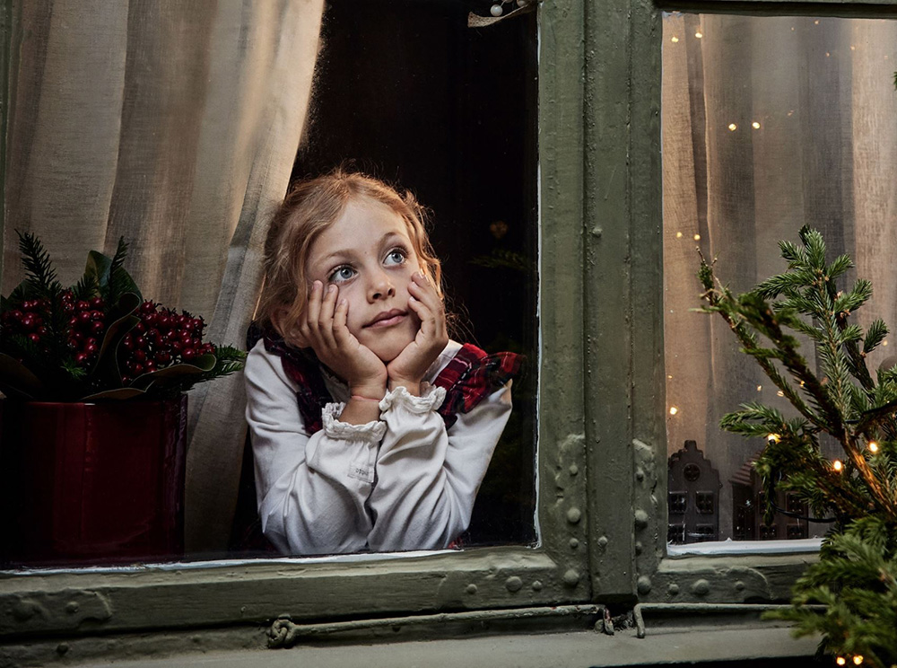 enfant regardant par la fenêtre maison avec décoration Noël traditionnel enfant regardant par la fenêtre maison avec décoration Noël traditionnel