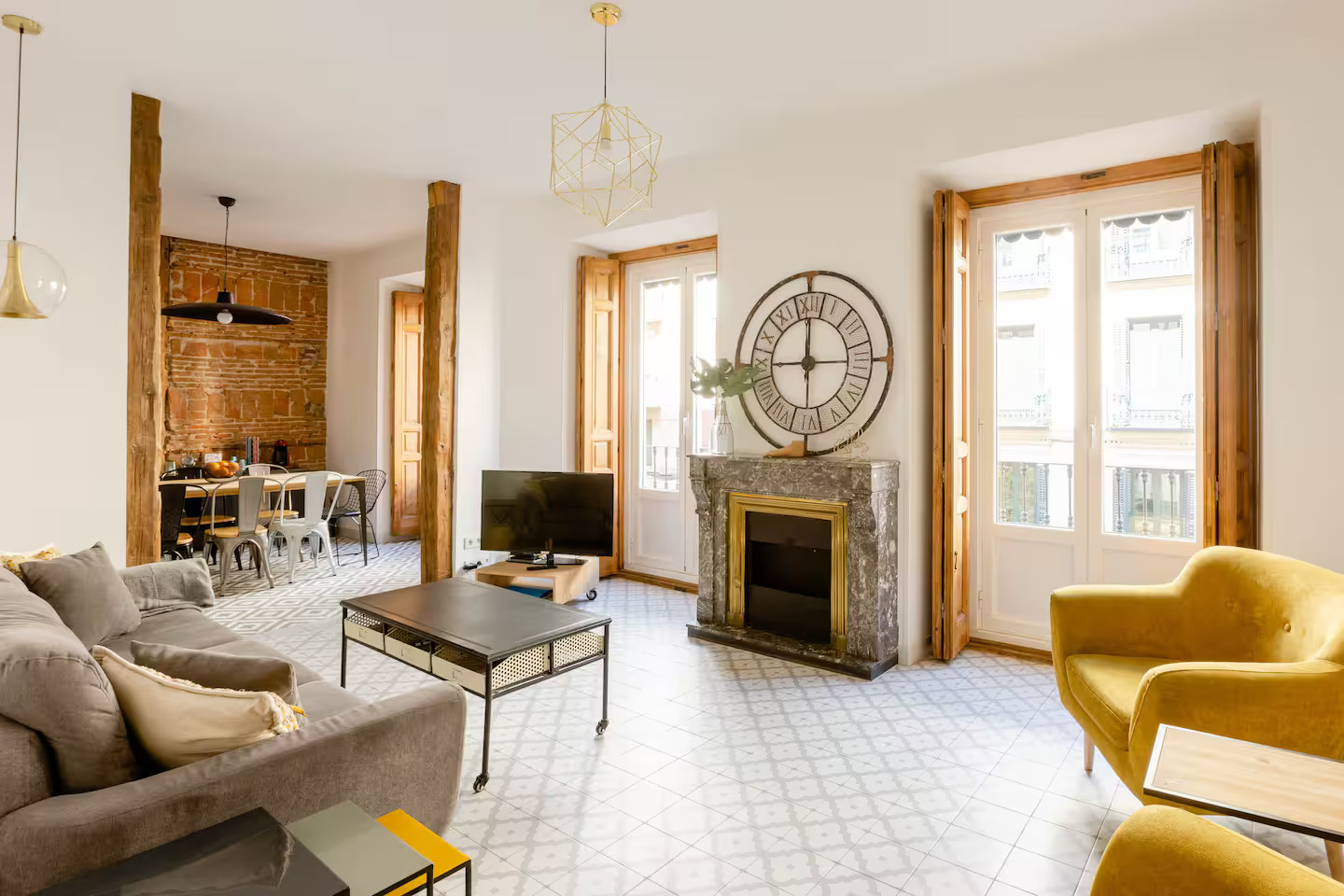 salon avec cheminée mur de briques et poutres appartement Madrid