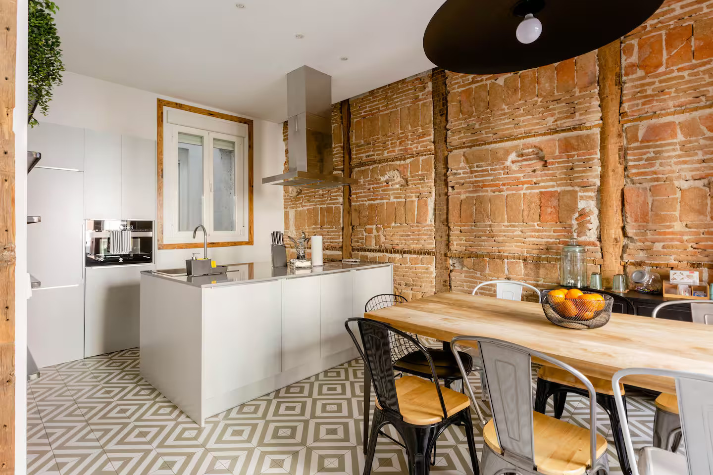 salle à manger et cuisine ouverte mur de briques et poutres appartement Madrid