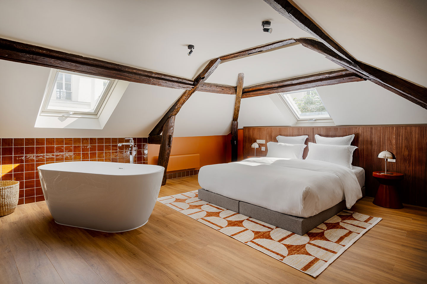chambre mansardée avec poutres et salle de bain ouverte