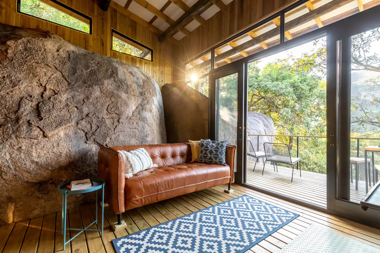 salon petite maison en bois entre deux rochers Tussenklip