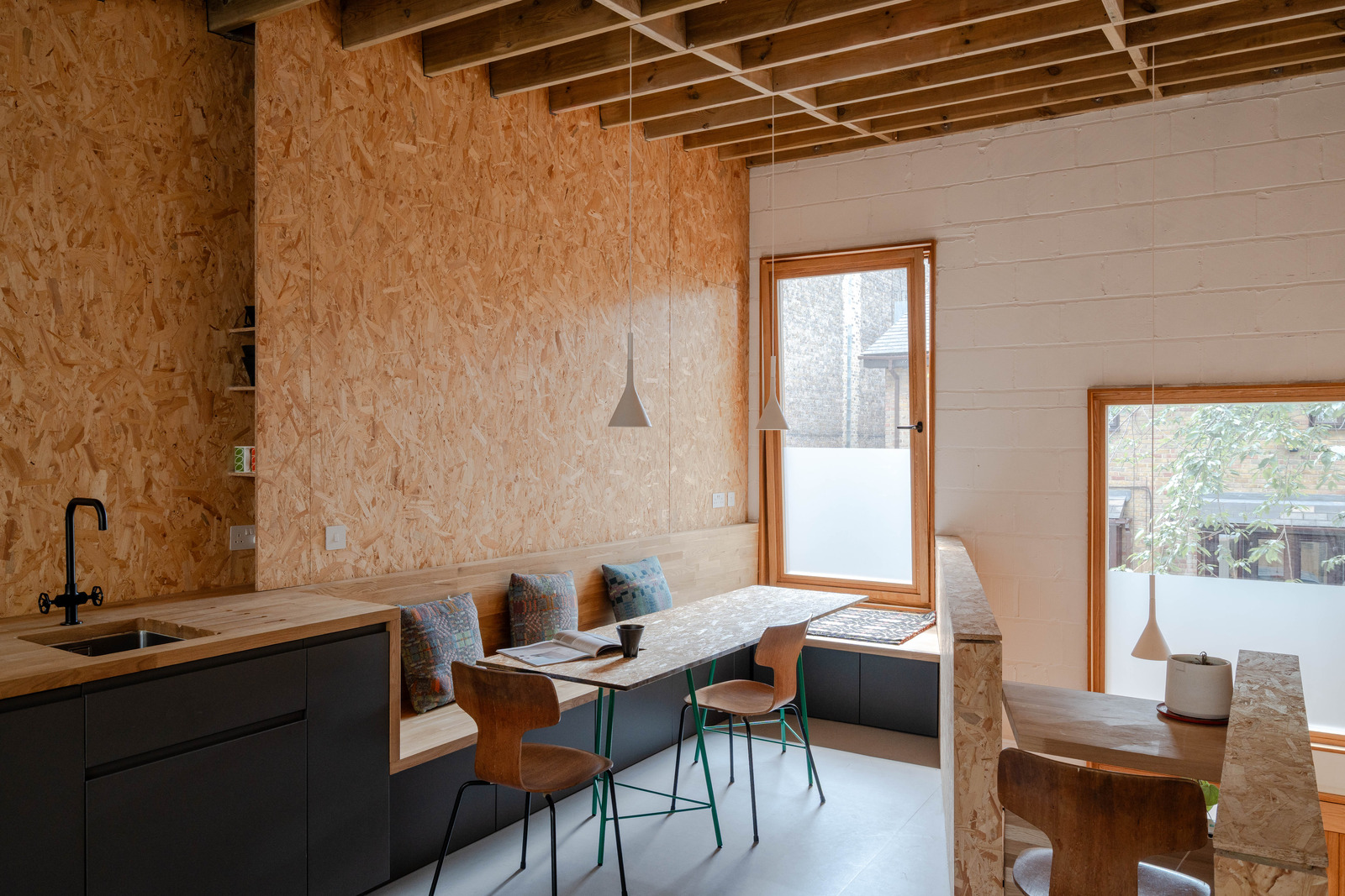 salle à manger et cuisine ouverte grise design murs OSB petite maison 51m2 salle à manger et cuisine ouverte grise design murs OSB petite maison 51m2