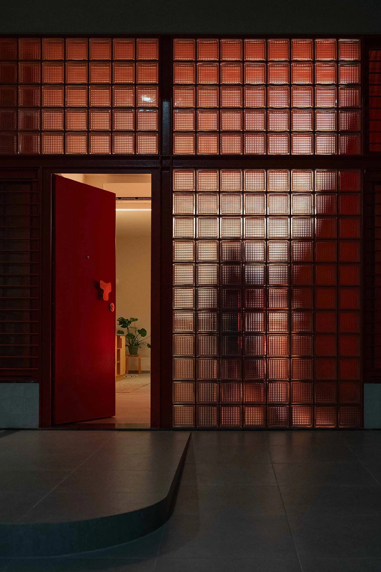 façade briques de verre porte en acier rouge appartement rénové 