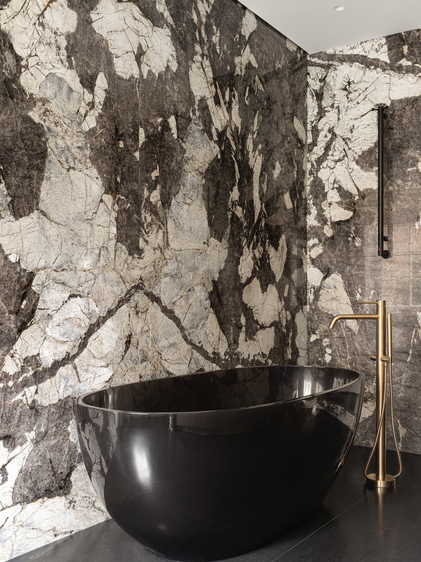 salle de bain design avec baignoire îlot murs marbre noir et blanc