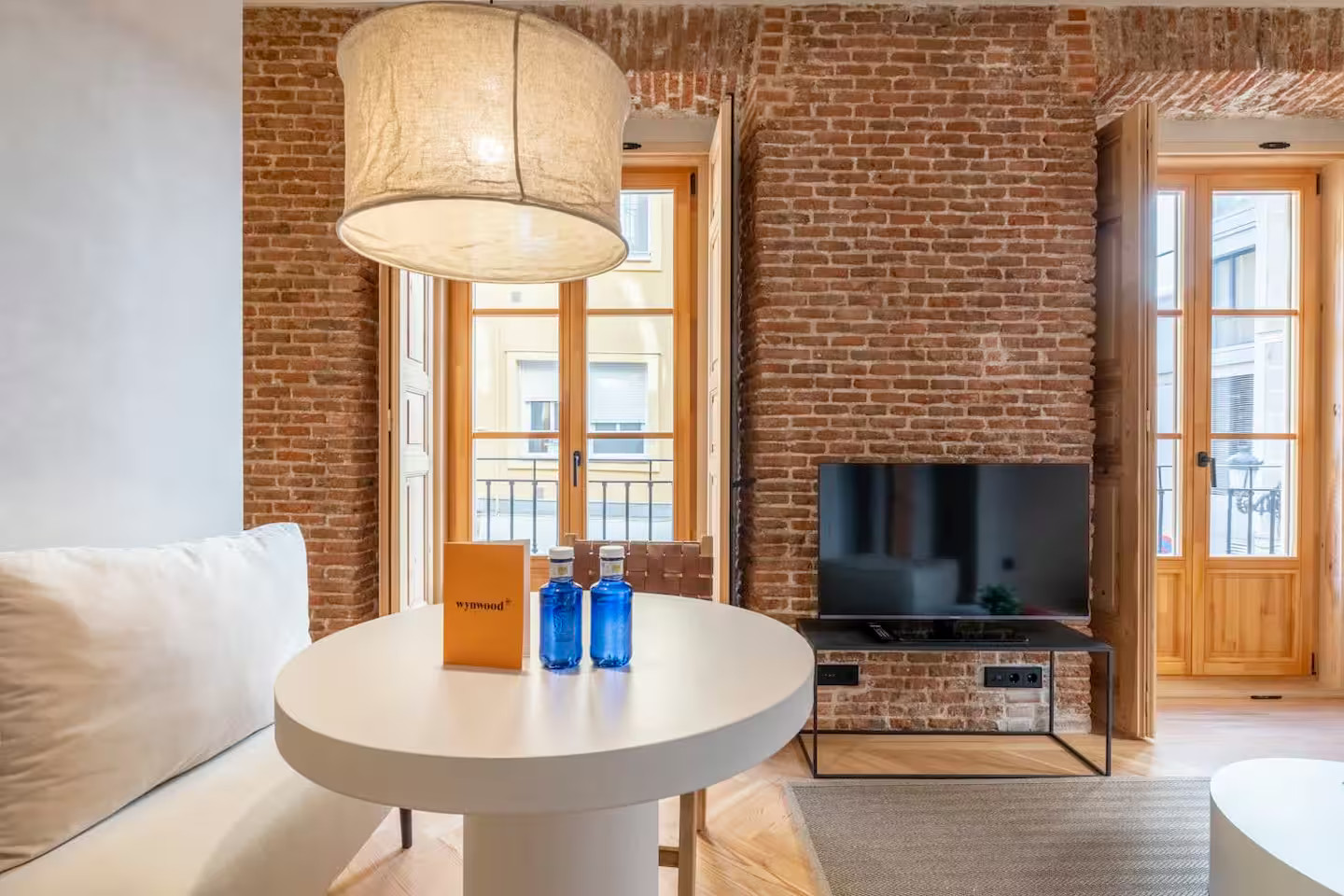 salon studio optimisé en deux-pièces avec murs briques et volets intérieurs salon studio optimisé en deux-pièces avec murs briques et volets intérieurs