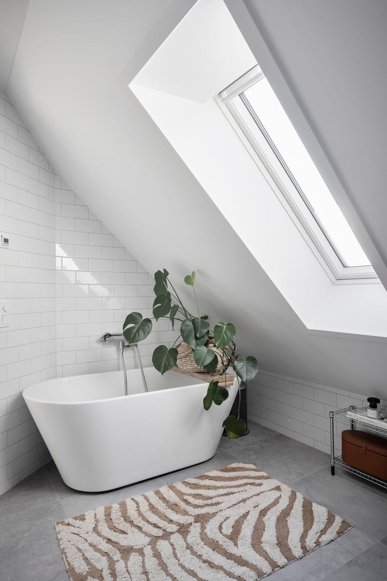 salle de bain mansardée et design avec baignoire îlot et velux