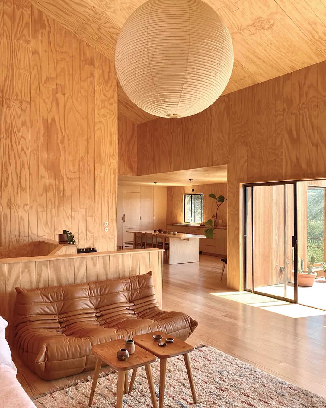 salon avec canapé Togo cuir mur en bois maison en bois Sea Ranch Californie