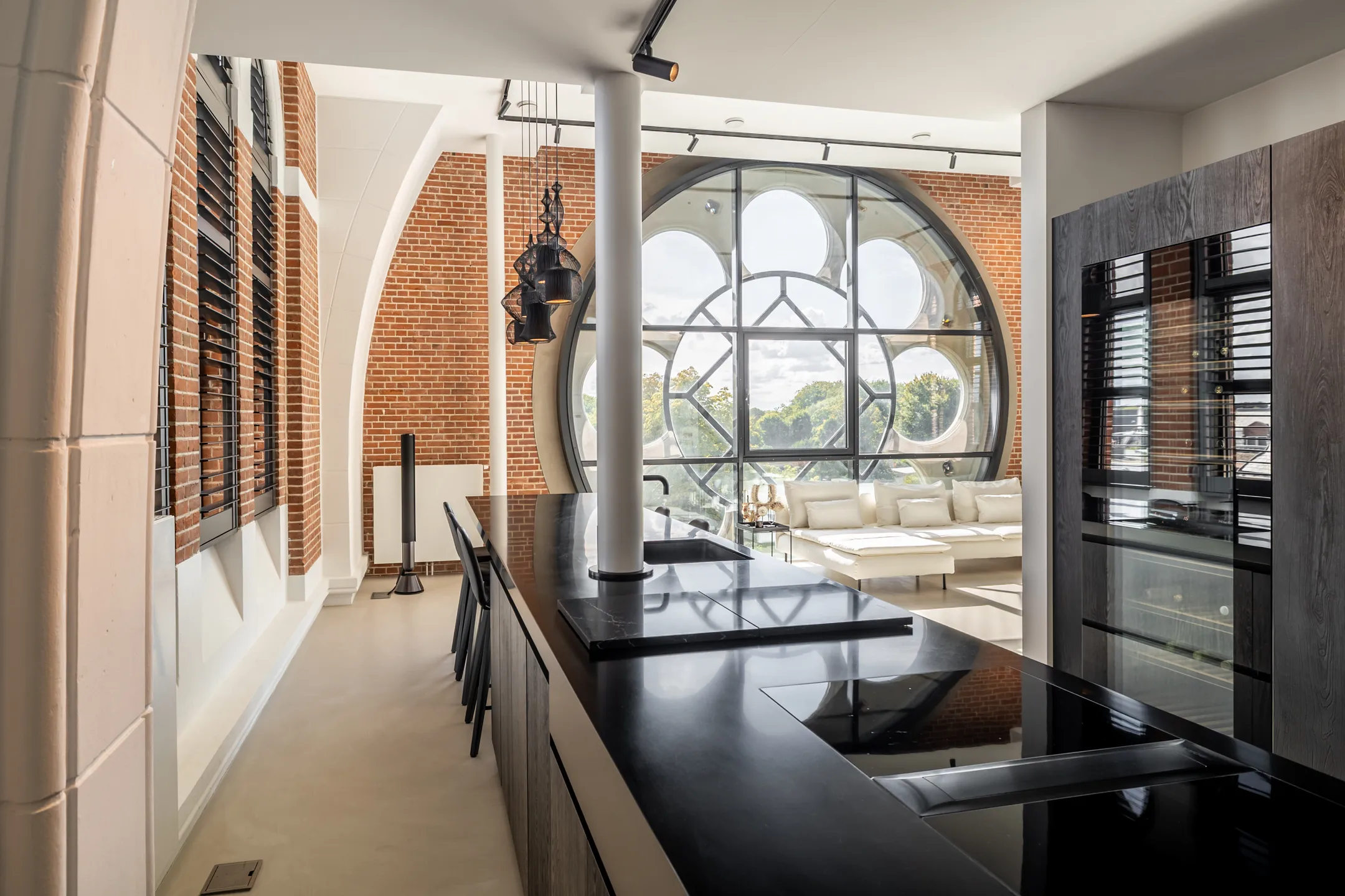 cuisine noire et salon avec baie vitrée ronde appartement design dans une ancienne église aux Pays-Bas cuisine noire et salon avec baie vitrée ronde appartement design dans une ancienne église aux Pays-Bas