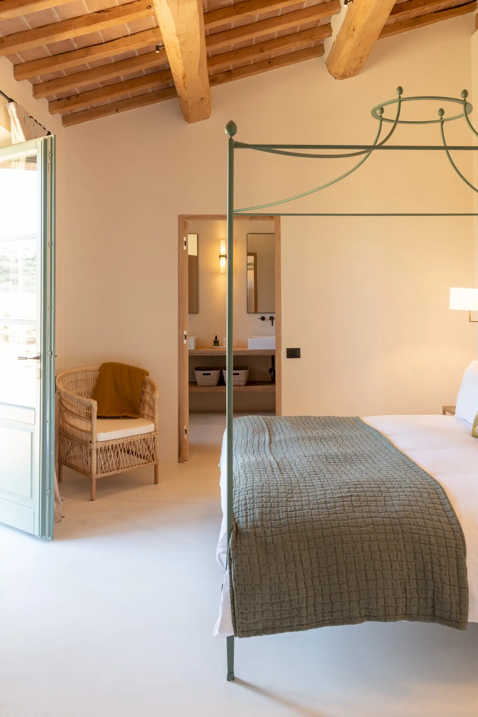 chambre avec lit baldaquin métal vert et poutres maison en pierres ancienne rénovée Podere Sirolo Italie chambre avec lit baldaquin métal vert et poutres maison en pierres ancienne rénovée Podere Sirolo Italie
