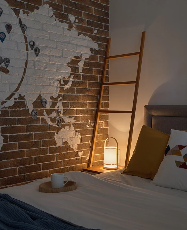 Coin nuit semi-fermé avec lit installé dans une alcôve lumineuse d'un studio de 40m2