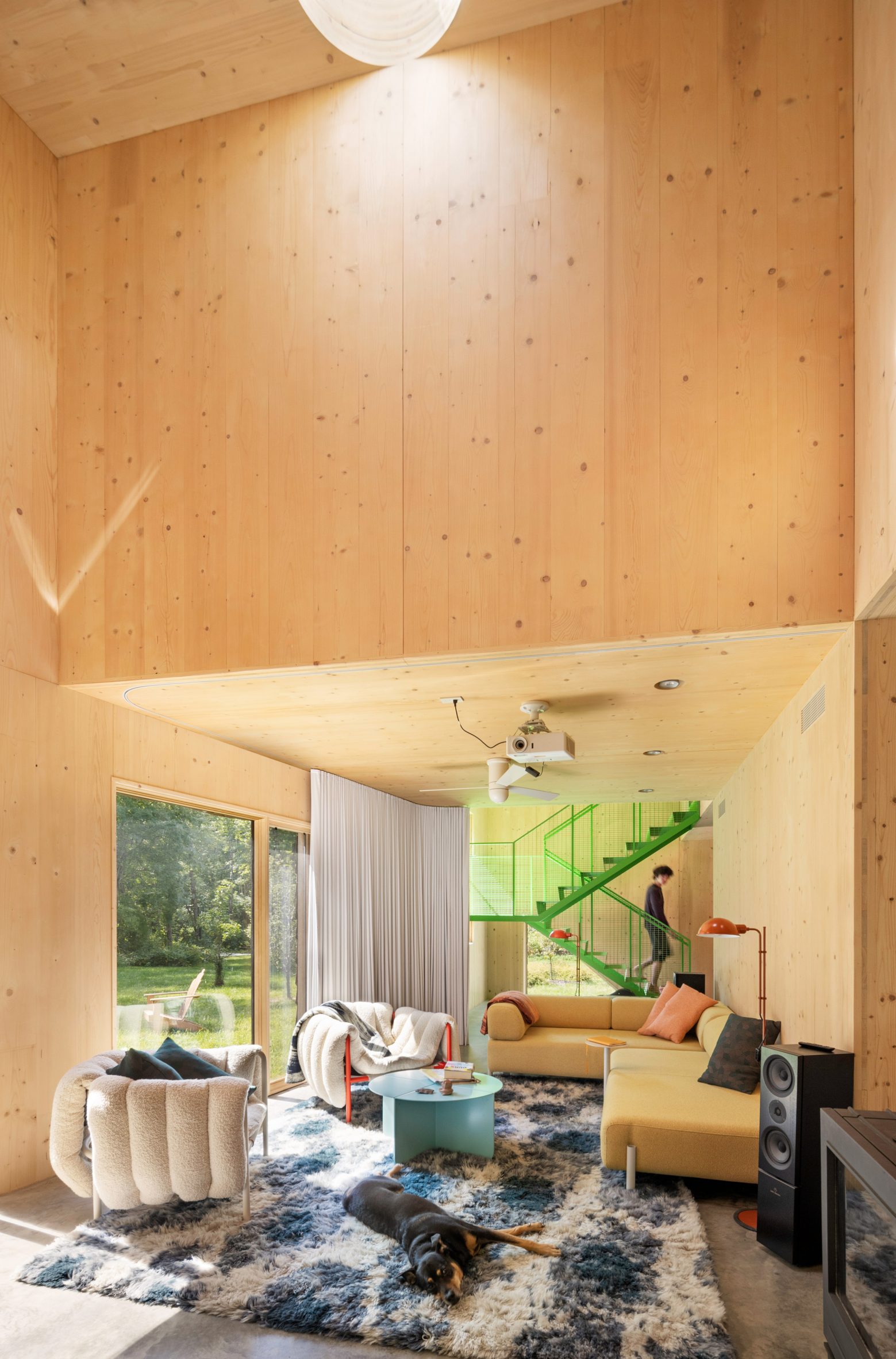 salon avec poêle et escalier métal vert décoration contemporaine grande maison préfabriquée en bois