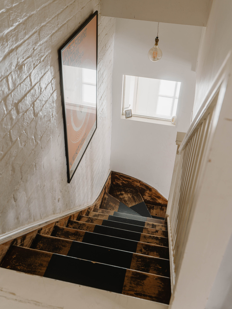 escalier ancien en bois murs briques blanches