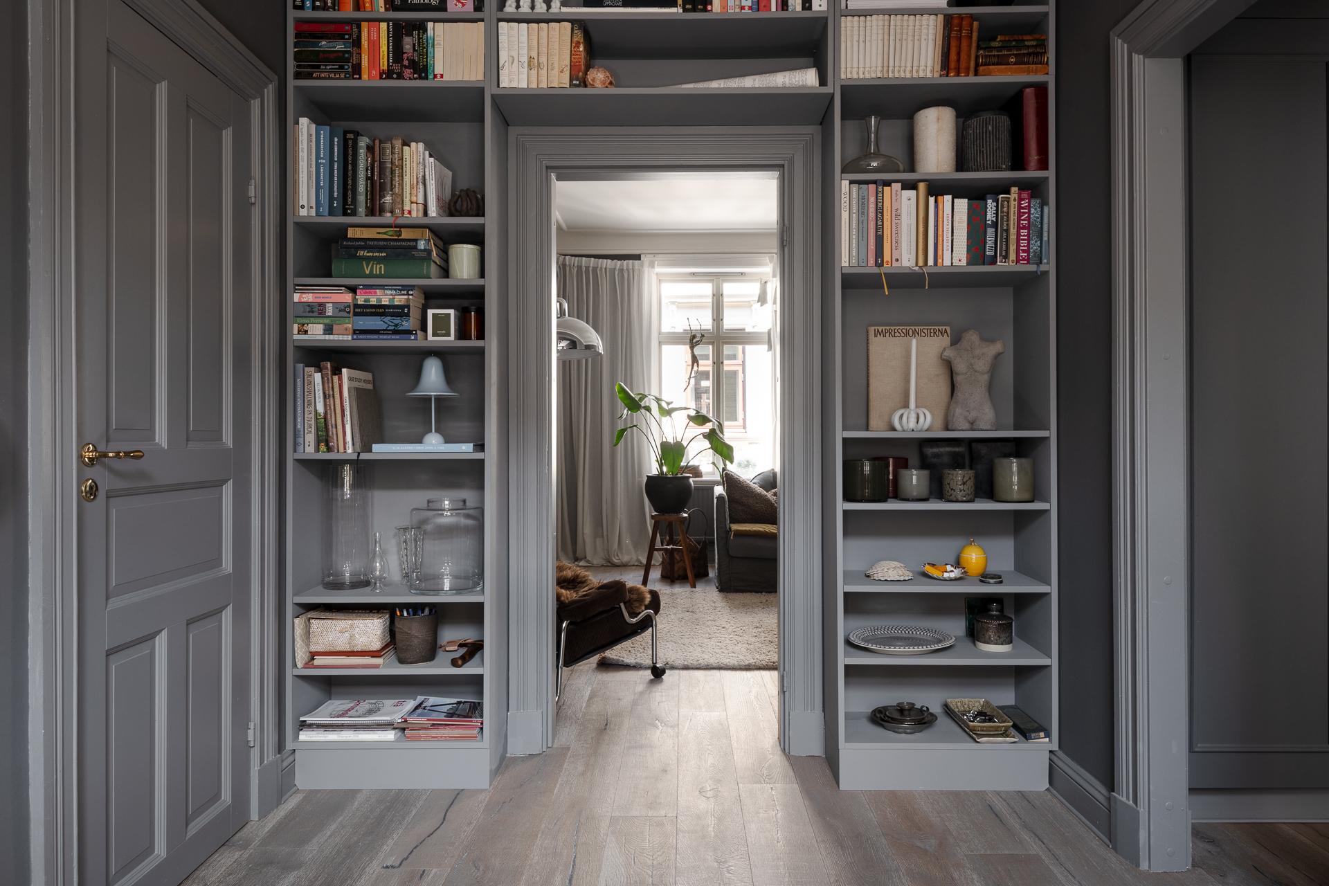 entrée murs gris deux-pièces 66m2 avec bibliothèque autour de la porte entrée murs gris deux-pièces 66m2 avec bibliothèque autour de la porte