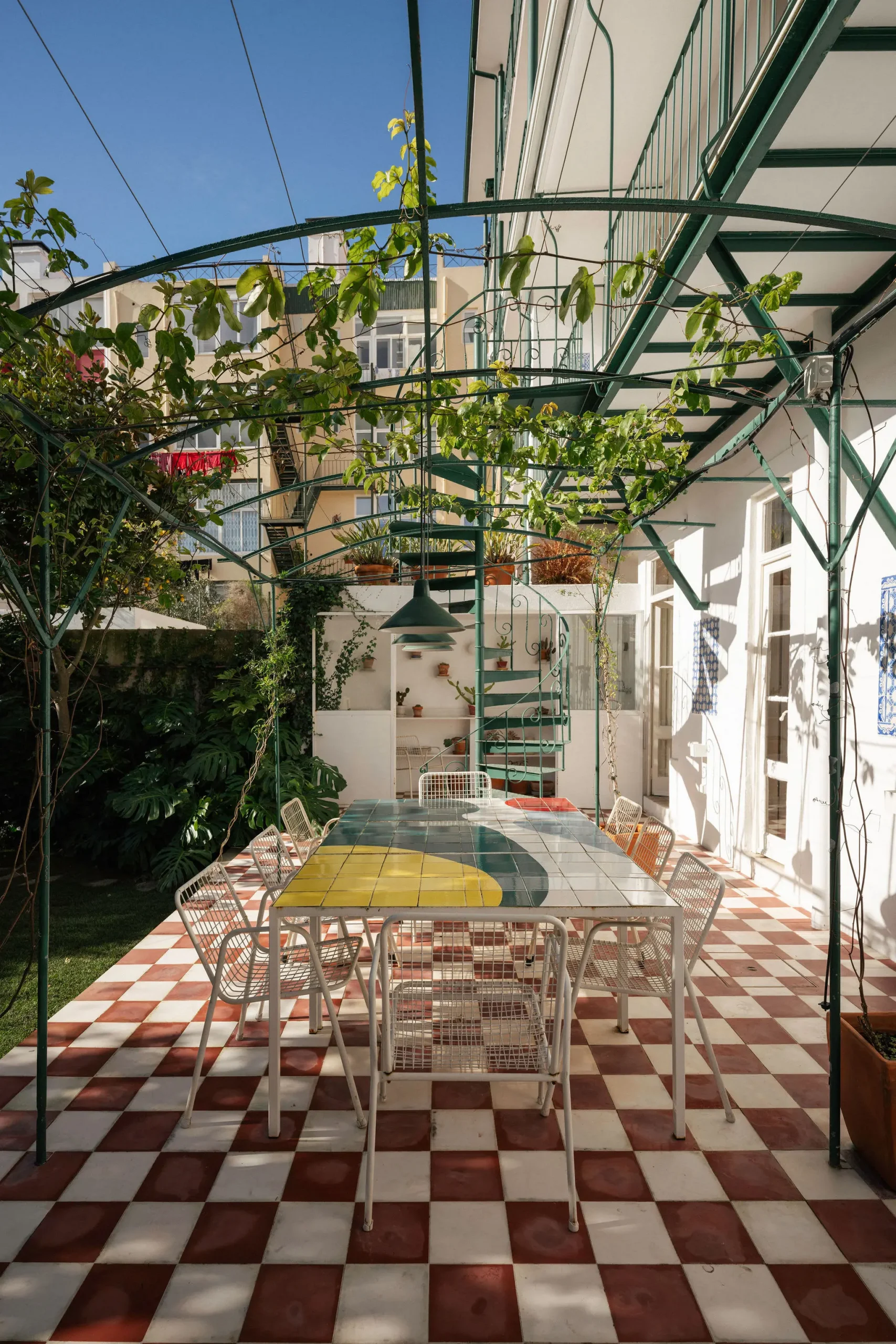 terrasse sol à damier rouge et blanc pergola métal vert maison de ville ancienne Lisbonne décoration vintage