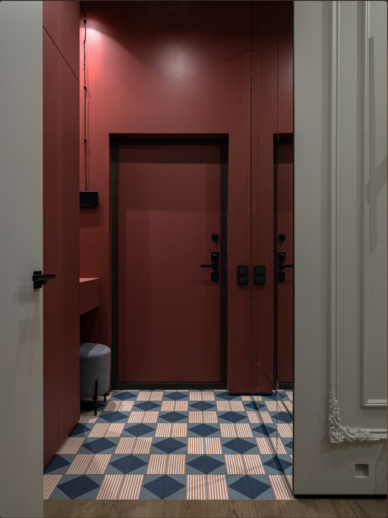 entrée avec carrelage à motif et murs rouge cerise