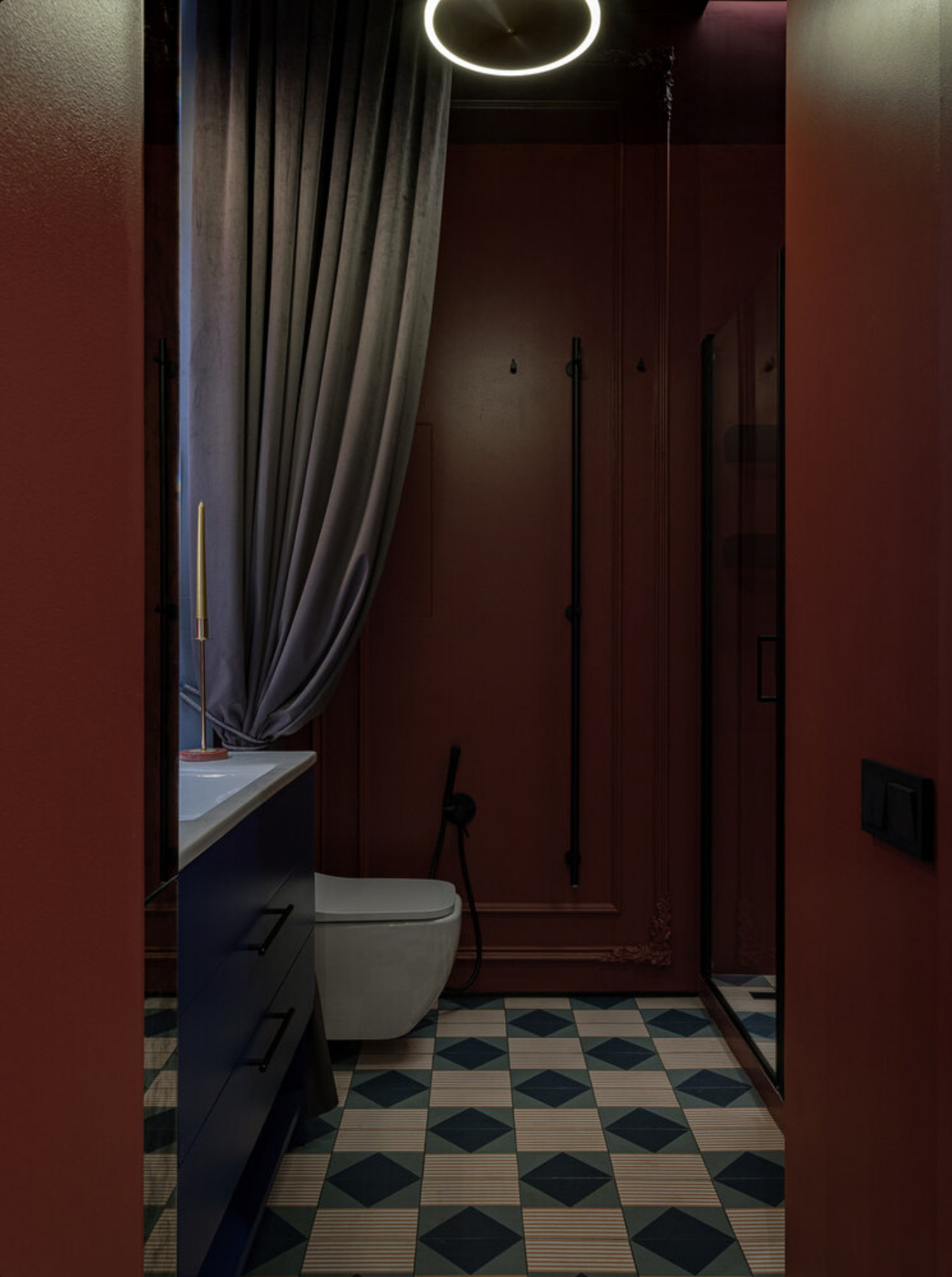 salle de bain avec carrelage à motif et murs rouge cerise