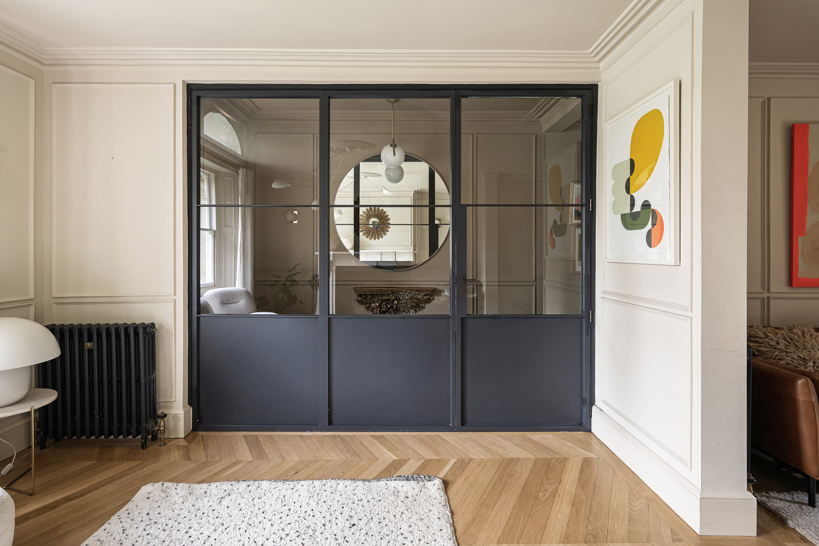 salon avec verrière noir métal décoration contemporaine dans maison accolée familiale rénovée en Angleterre
